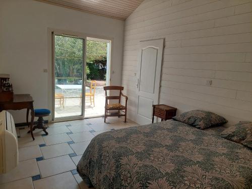 une chambre avec un lit, un bureau et une fenêtre dans l'établissement sable gris maison d'architecte, à Andernos-les-Bains