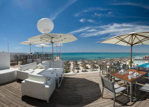 a patio with white furniture and a view of the beach at The Sindbad in Hammamet