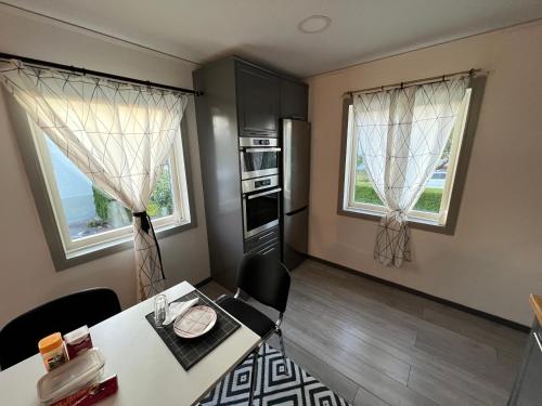 a kitchen with a table and chairs and two windows at Villa ICRE 23A in Överum
