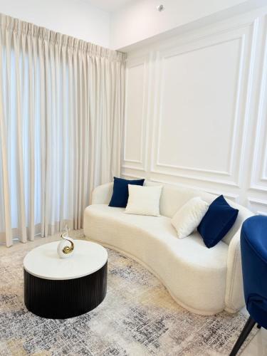 a white living room with a couch and a table at Chevalra Luxury TRI-ZEN Apartment in Central Colombo - Galle-Face & Lotus Tower View in Colombo