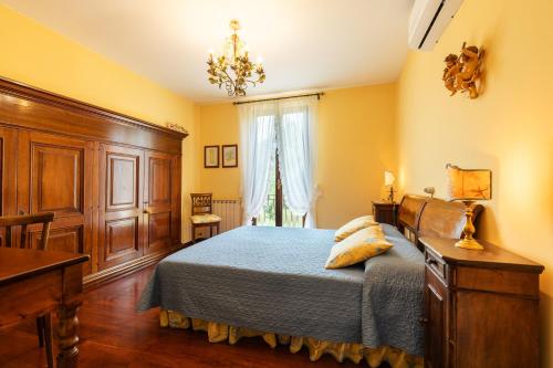 a bedroom with a bed and a dresser and a window at VILLA COSTANZA 6, Emma Villas in Fivizzano