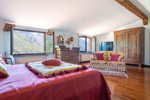 a bedroom with a bed and a couch and a window at VILLA COSTANZA 6, Emma Villas in Fivizzano