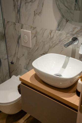 a bathroom with a white sink and a toilet at Ionian Blue Apartament 6 in Himare