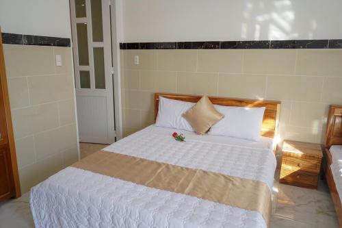 a bedroom with a white bed with a flower on it at Hotel Hoai Anh in Vung Tau