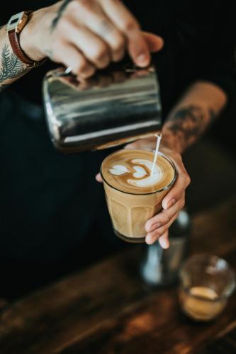 a person is holding a cup of coffee at The Ald Hotel in The Hague
