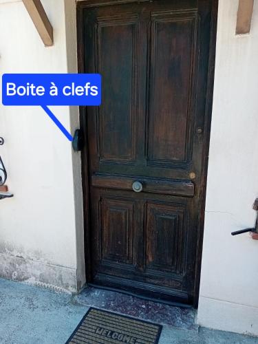 une porte en bois avec un panneau indiquant « bouteille a cities » dans l'établissement Sunset Cagnes, à Cagnes-sur-Mer