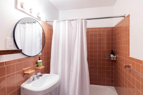 a bathroom with a white shower curtain and a sink at The Perch Hotel in East Windham