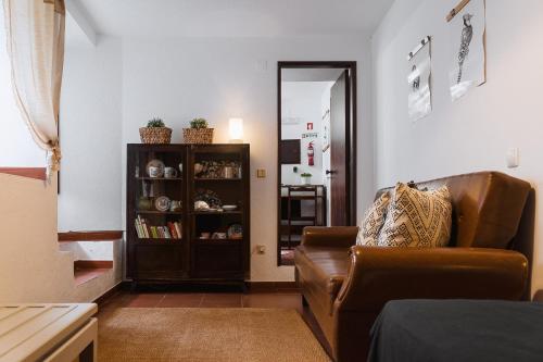 a living room with a couch and a book shelf at Óbidos Priest Room in Óbidos