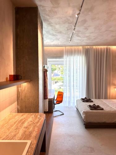 a bedroom with a bed and a desk and a window at Theros in Rethymno