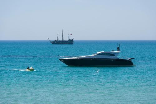 a boat in the water with a person swimming next to it at The Sindbad in Hammamet