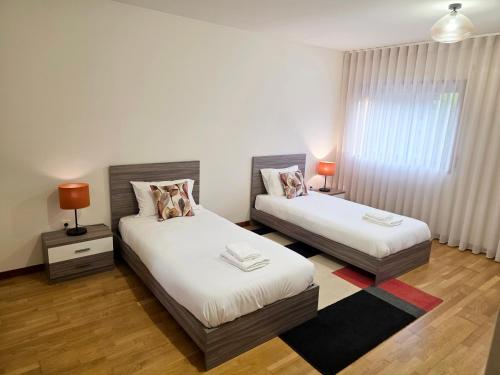 a bedroom with two beds and a window at Villarmo cais in Viana do Castelo