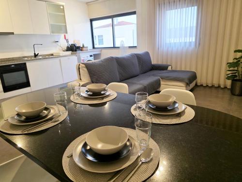 una sala de estar con una mesa con platos y vasos. en Villarmo cais, en Viana do Castelo