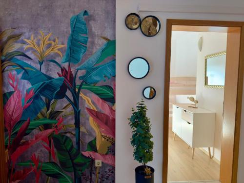 un couloir avec un mur avec une fresque de feuilles dans l'établissement Apartments Dalmatino, à Kaštela