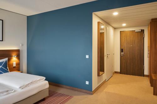 a bedroom with a blue wall and a bed at Four Points Flex by Sheraton Essen in Essen