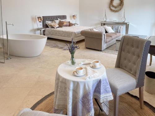sala de estar con mesa y bañera en Mas La Rose Sauvage - magnificent Luberon views, en Murs