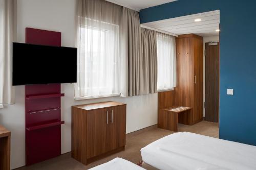 a room with a bed and a television in it at Four Points Flex by Sheraton Essen in Essen