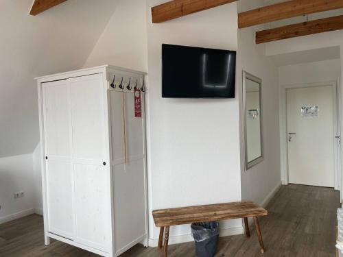 a room with a white cabinet and a bench at Hotel Deichvoigt in Cuxhaven