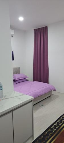 Un dormitorio con una cama morada y una ventana. en Teratak Sumayyah - For Islam Only - Pondok Lenggong, en Kampong Banggol Belimbing