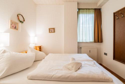 a bedroom with a white bed with towels on it at Alpenhof M&E in Bad Kleinkirchheim