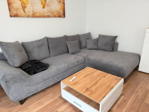 a grey couch in a living room with a wooden table at Seewinkelruh in Frauenkirchen