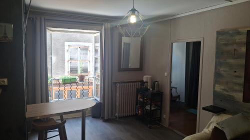 a living room with a table and a window at COSY B&B in Murat