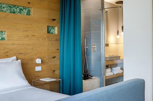 a bedroom with a bed and a glass shower at Astoria Resort in Riva del Garda
