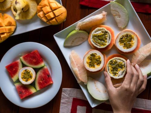 uma mesa com um prato de comida com ovos e frutas em Kadju House em Tangalle