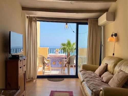 un soggiorno con divano, TV e balcone di Casa Blue Bayou a Villajoyosa