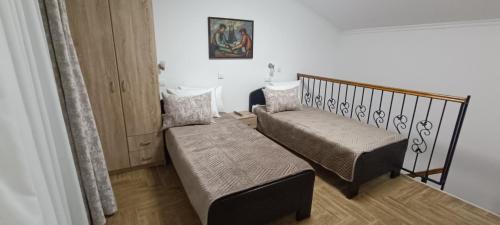 a small room with two beds and a bench at Petrovaradinski Dvor in Petrovaradin