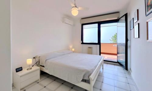 En eller flere senge i et værelse på Bilocale con piscina condominiale