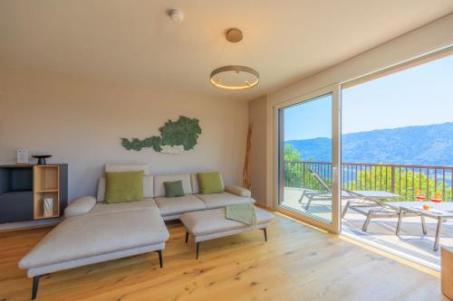 a living room with a couch and a large window at Adlerblick Penthouse mit Seeblick in Annenheim