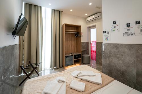 a bedroom with a bed with two towels on it at GreRos Toledo H Historical Center in Naples, by ClaPa Group Dislocated Hospitality in Naples