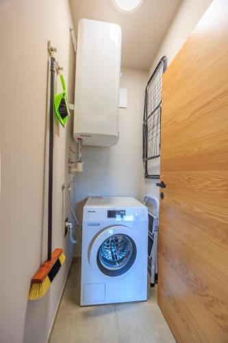a washer and dryer in a room with a door at Adlerblick Penthouse mit Seeblick in Annenheim