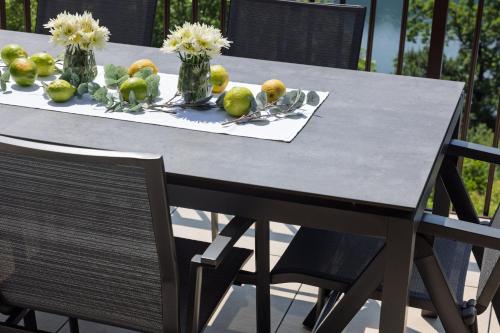 a table with vases of fruit and flowers on it at Adlerblick Penthouse mit Seeblick in Annenheim