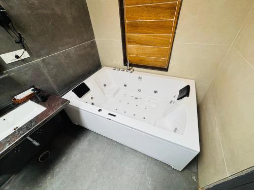 a white bath tub in a bathroom with a sink at Anandam - A Luxury Resort in Udaipur in Udaipur