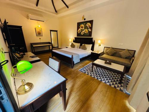 a hotel room with a bed and a couch at Anandam - A Luxury Resort in Udaipur in Udaipur