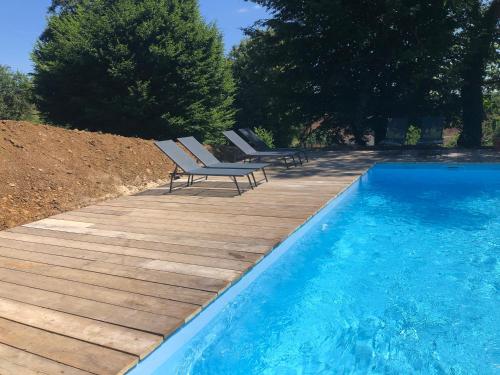 une piscine avec deux chaises longues à côté d'une terrasse en bois dans l'établissement Le Pasteur Danseur, à Graffigny-Chemin
