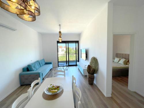 a living room with a couch and a table and chairs at Prestige Rentals - Radhimë in Vlorë