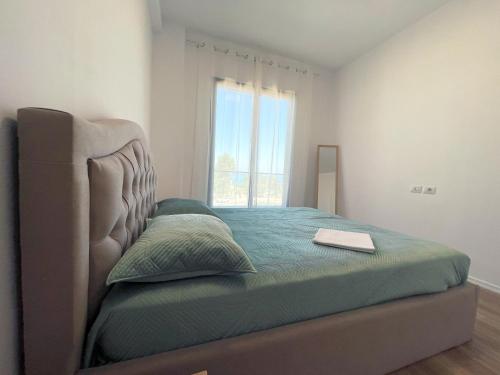 a bedroom with a bed with a large window at Prestige Rentals - Radhimë in Vlorë