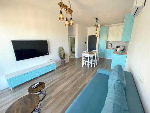 a living room with a couch and a flat screen tv at Prestige Rentals - Radhimë in Vlorë