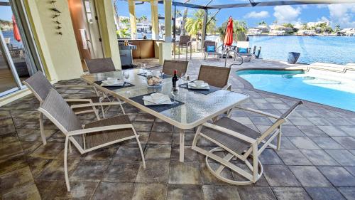 a dining table and chairs next to a swimming pool at Rosegarden - PoolSpa and perfect water view in Cape Coral