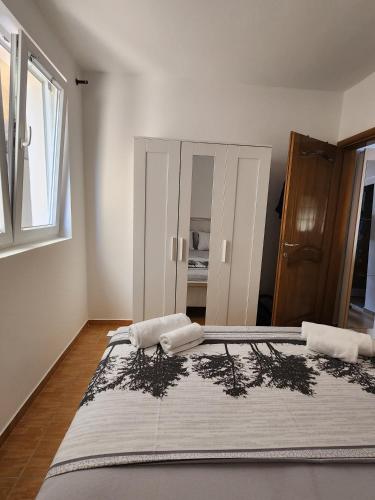 a bedroom with a large bed with two towels on it at Sunny Apartment in Prijevor