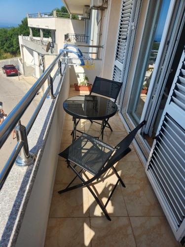 a balcony with a table and two chairs on it at Sunny Apartment in Prijevor