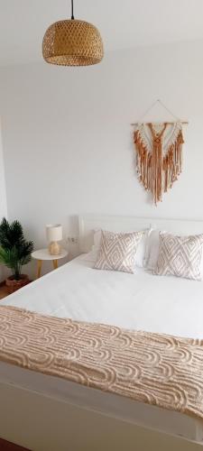 a bedroom with a white bed and a potted plant at Vila Onur Techirghiol in Techirghiol