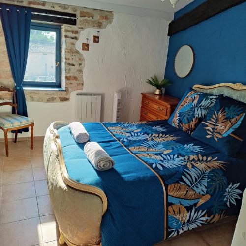 Un dormitorio con una cama con un edredón azul. en Les Écuries, 