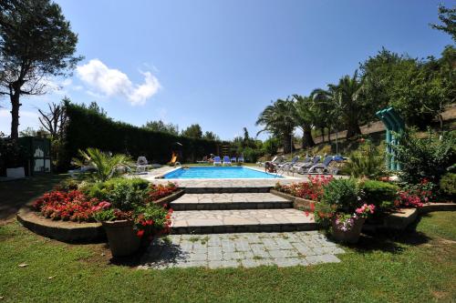 a swimming pool with plants and flowers in a yard at Hotel O Sole Mio in SantʼAgata sui Due Golfi
