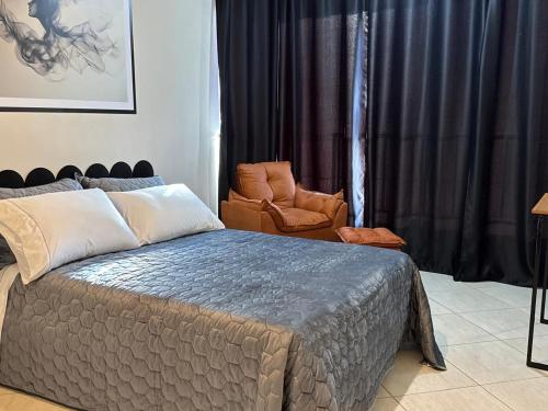 a bedroom with a bed and a chair at APARTAMENTO no CENTRO 1 WI-FI GARAGEM in Vacaria