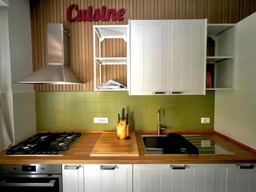 a kitchen with white cabinets and a sink and a stove at L'appartamento recchese in Recco