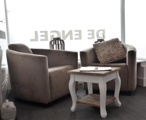 a living room with two chairs and a coffee table at Hotel Restaurant de Engel in Lisse