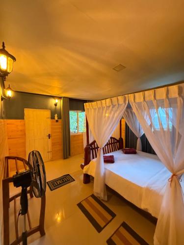 a bedroom with a bed with a mosquito net at Guest Inn Avendra in Ella